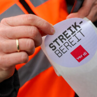 Eine Frau zieht einen Verdi Aufkleber „Streik-Bereit“ vom Papier. Warnstreik im öffentlichen Dienst in Rheinland-Pfalz, Kundgebung Verdi, Malakoff-Terrasse, Mainz.